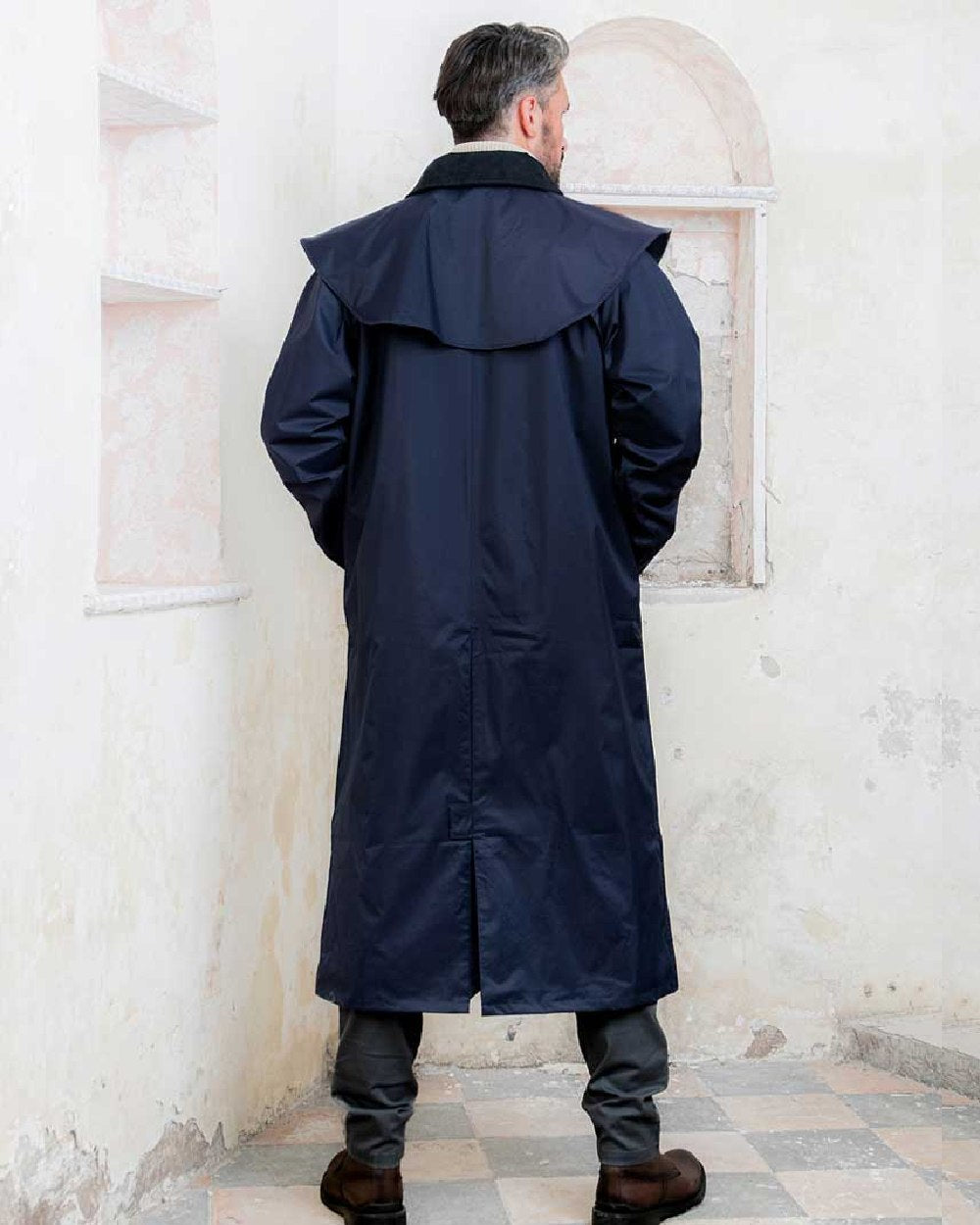 Navy coloured Jack Murphy Lambourne Mens Long Bush Coat on wall background