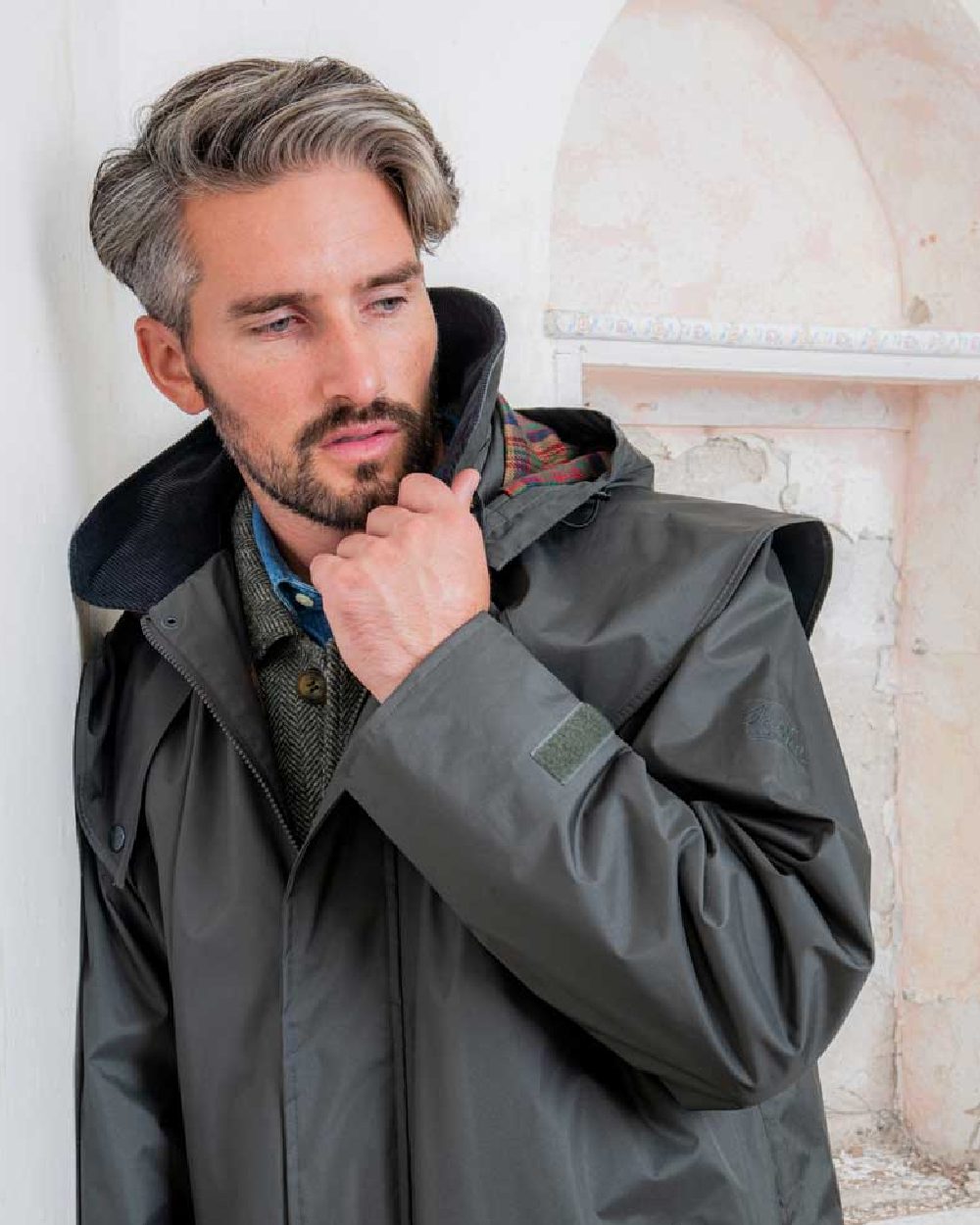 Olive coloured Jack Murphy Lambourne Mens Long Bush Coat on wall background