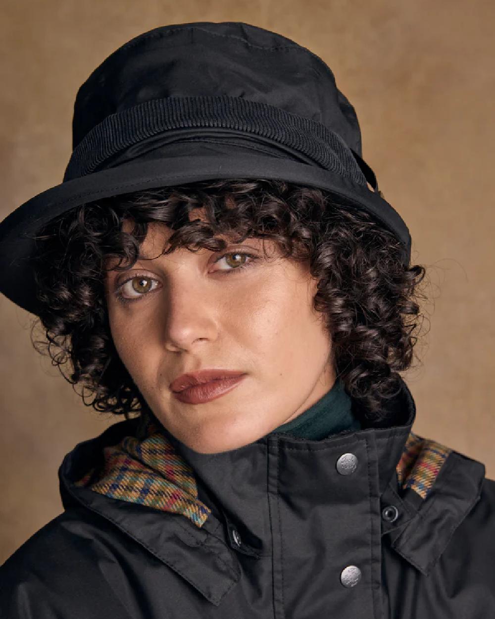 Black coloured Jack Murphy Malvern Heritage Rain Hat on wall background