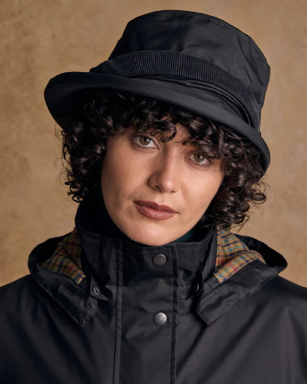 Black coloured Jack Murphy Malvern Heritage Rain Hat on wall background