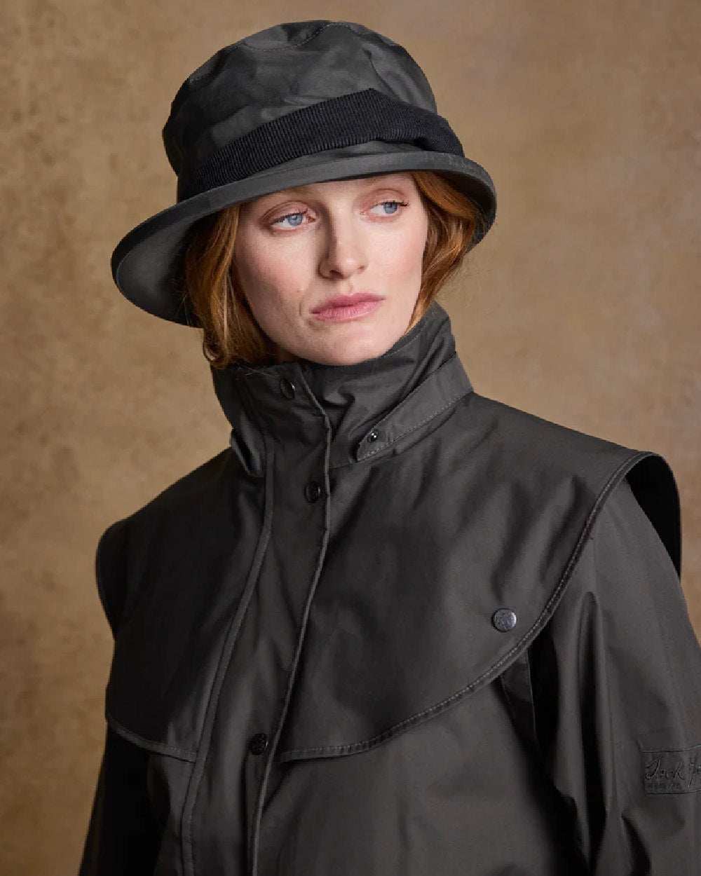 Olive coloured Jack Murphy Malvern Heritage Rain Hat on wall background