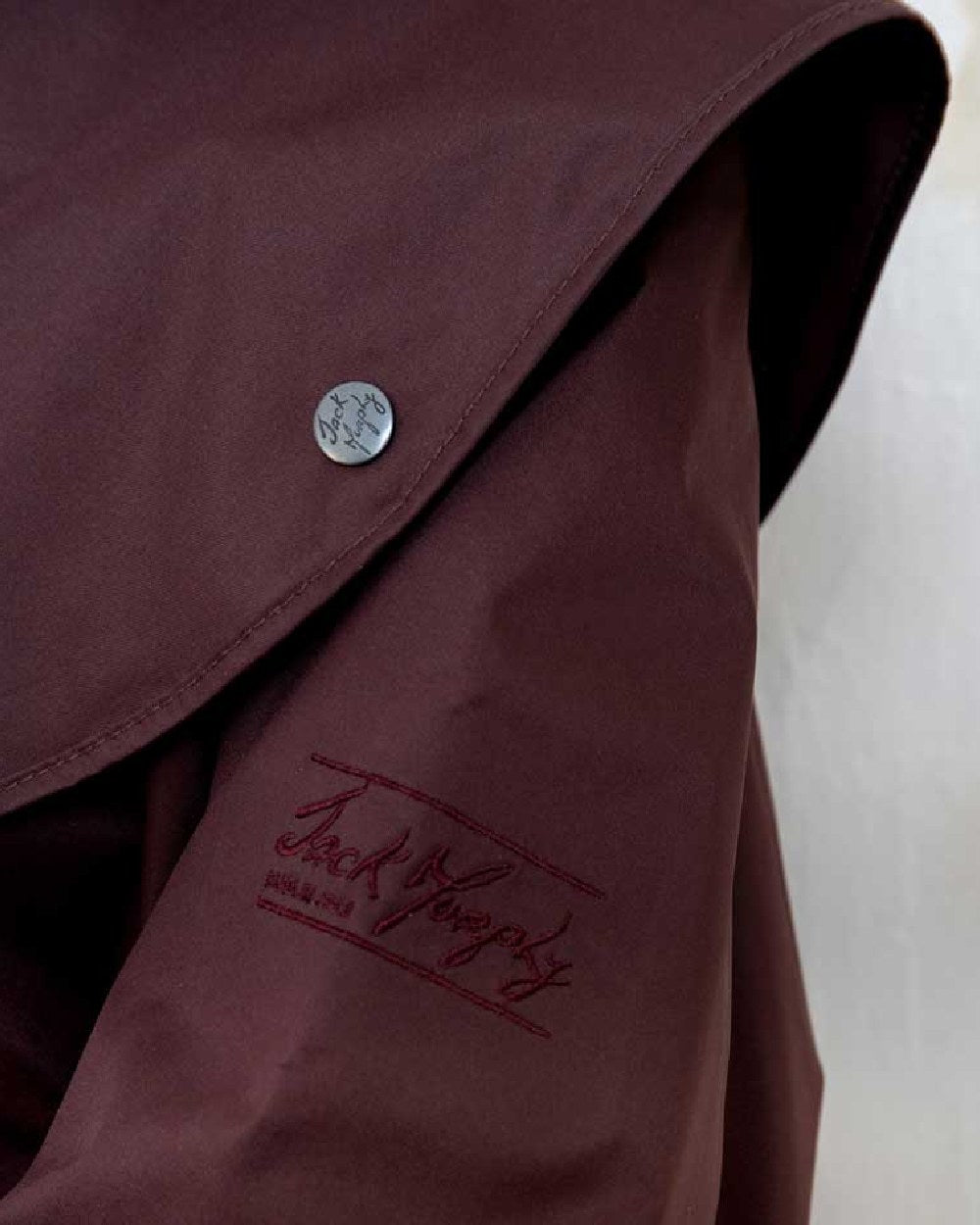 Deep Claret coloured Jack Murphy Malvern Ladies Waterproof Bush Coat on wall background