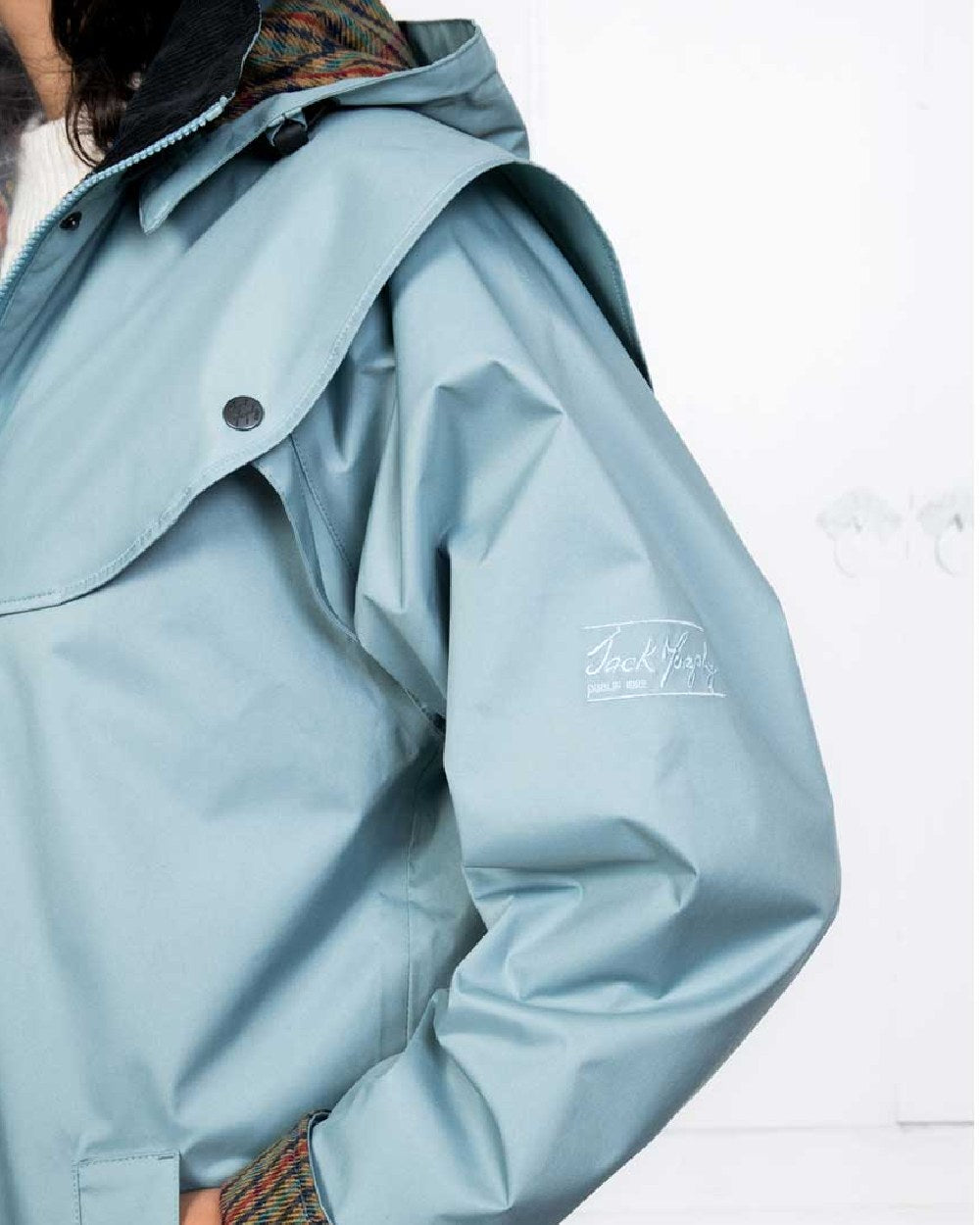Smokey Blue coloured Jack Murphy Malvern Ladies Waterproof Bush Coat on wall background