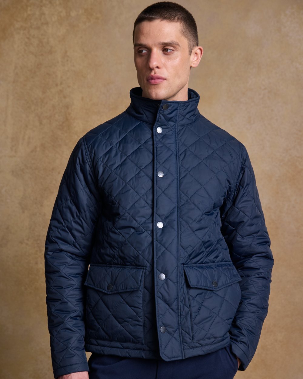 Navy coloured Jack Murphy Ronan Quilted Jacket on wall background