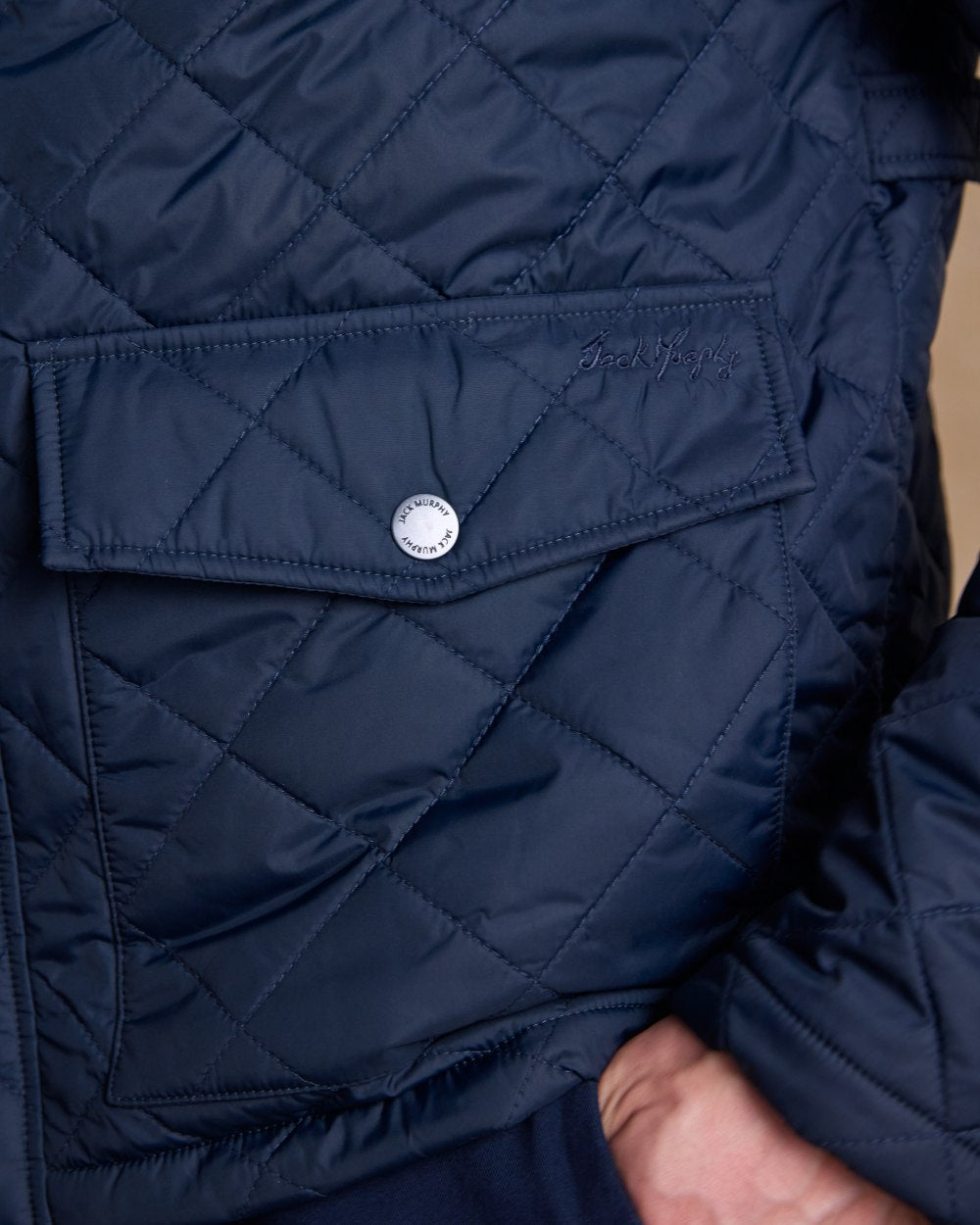 Navy coloured Jack Murphy Ronan Quilted Jacket on wall background