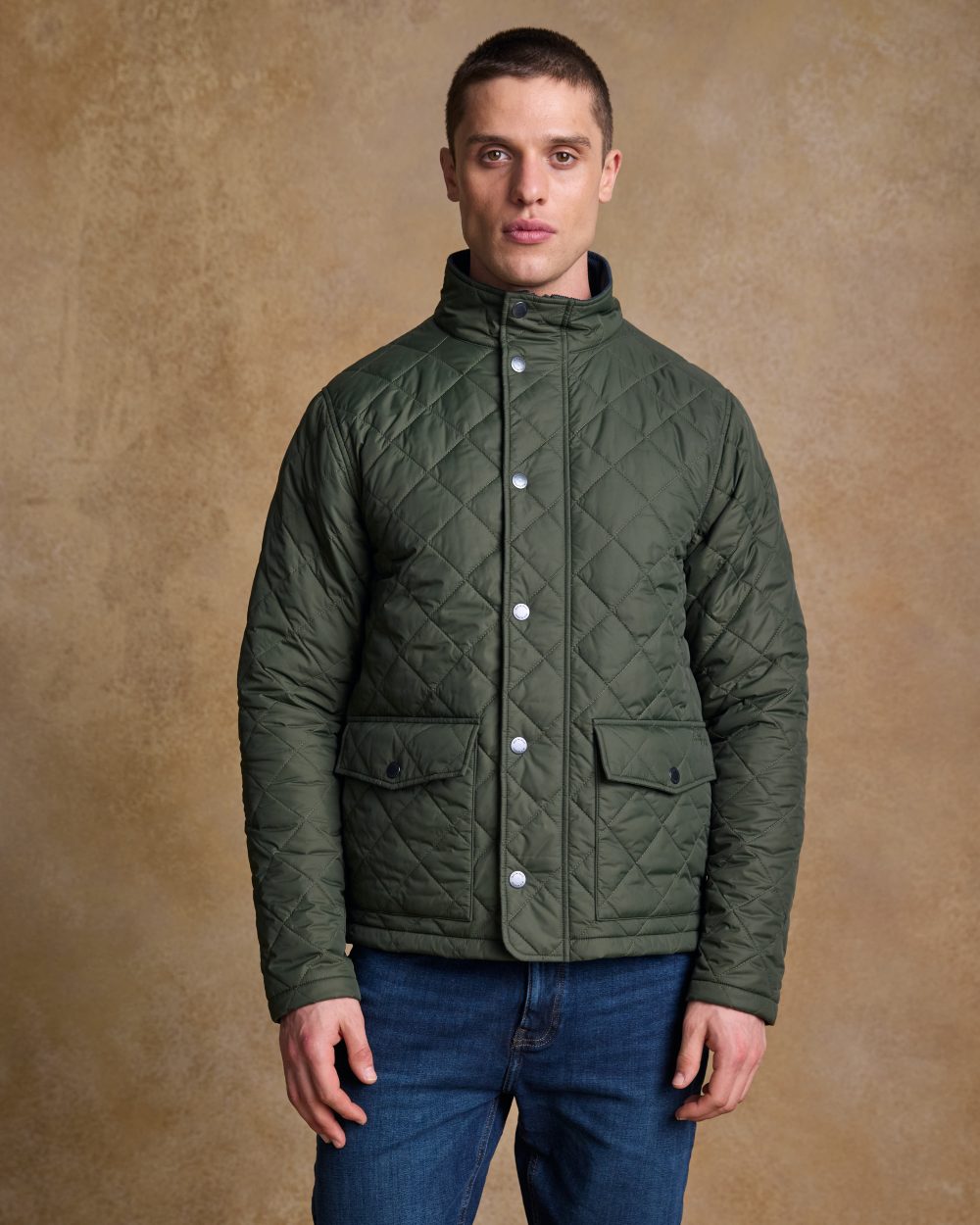 Olive coloured Jack Murphy Ronan Quilted Jacket on wall background