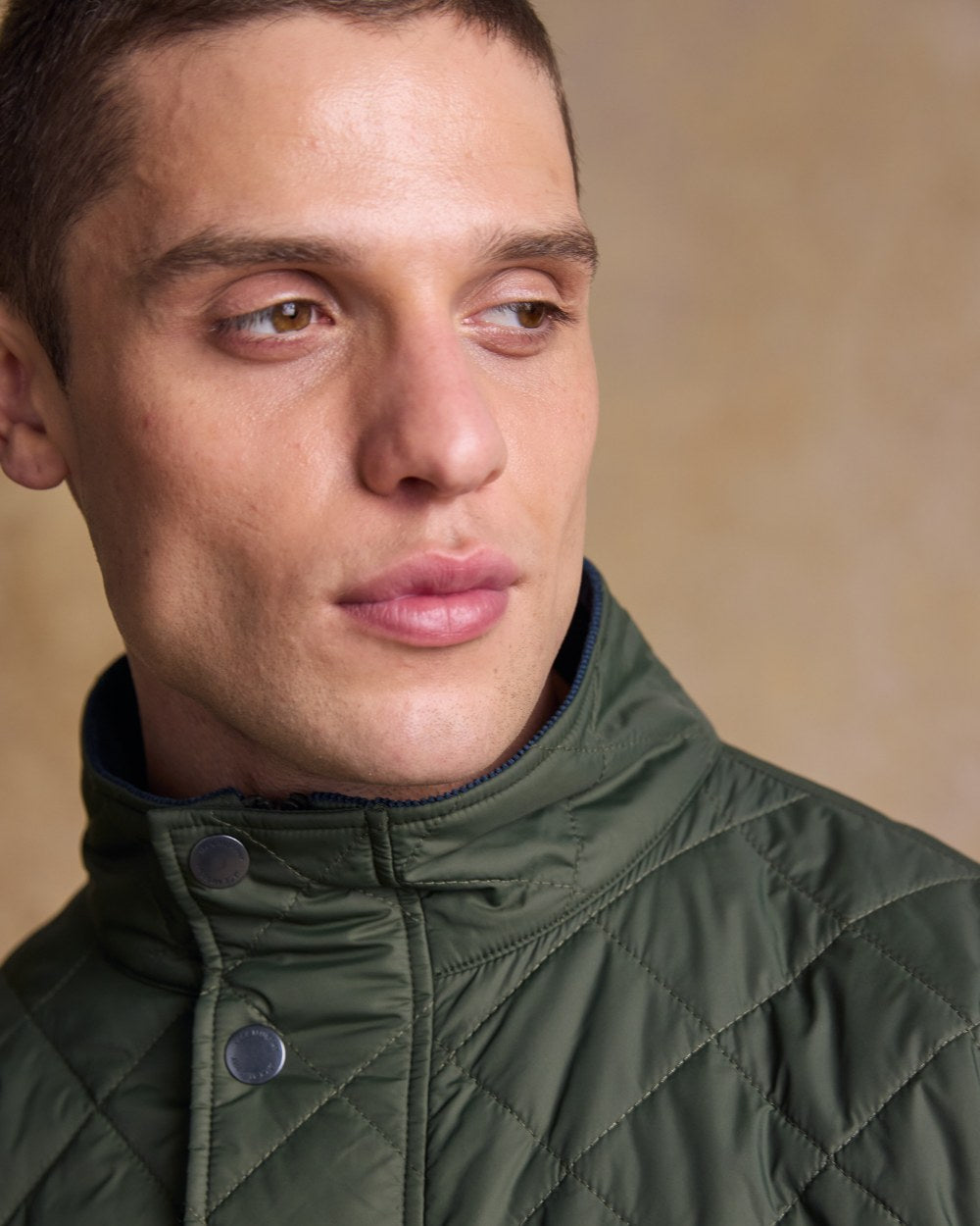Olive coloured Jack Murphy Ronan Quilted Jacket on wall background