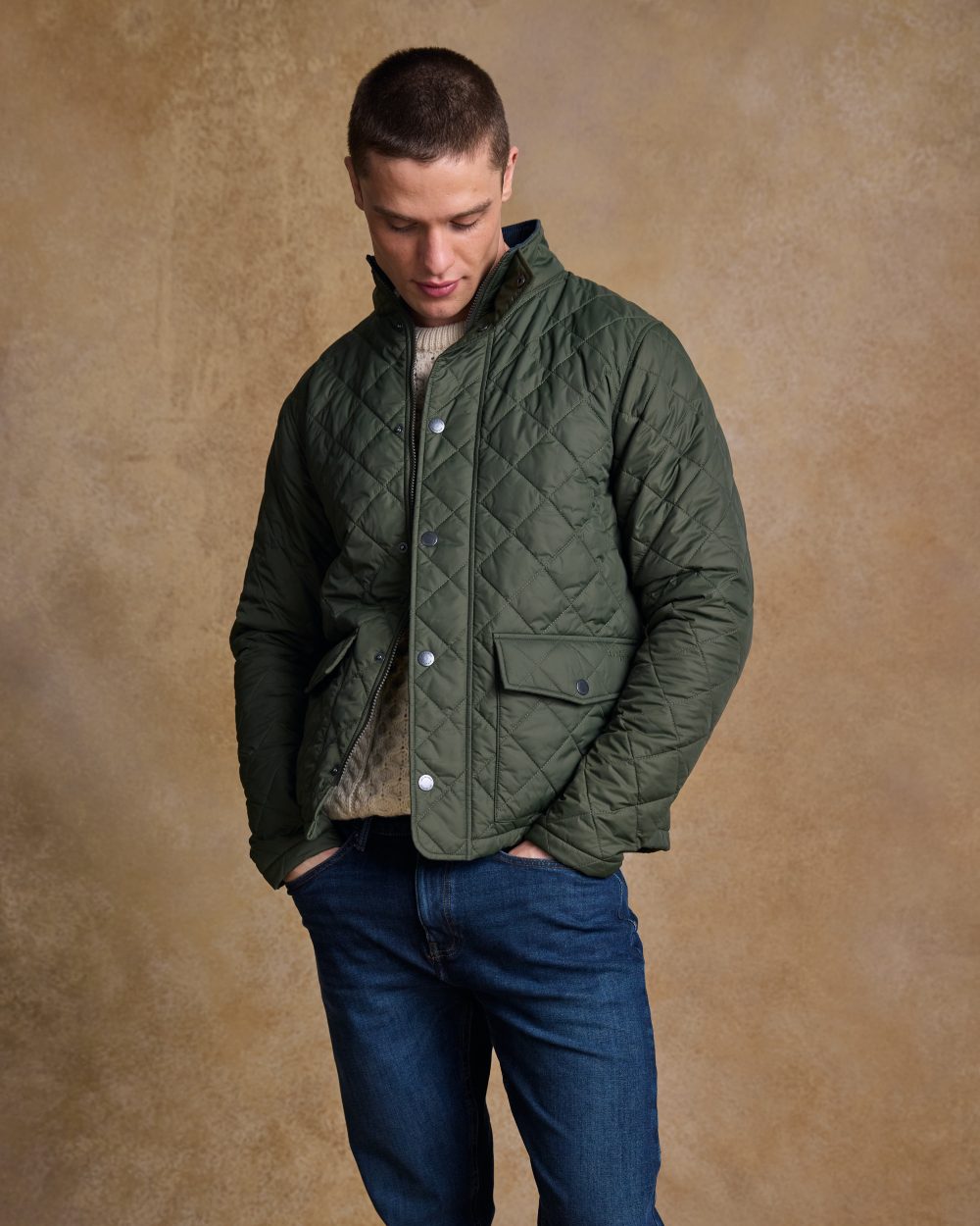 Olive coloured Jack Murphy Ronan Quilted Jacket on wall background