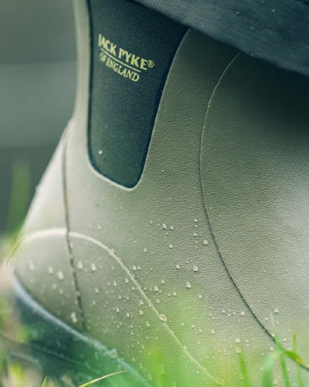 Green coloured Jack Pyke Ankle Wellington Boots on grass background
