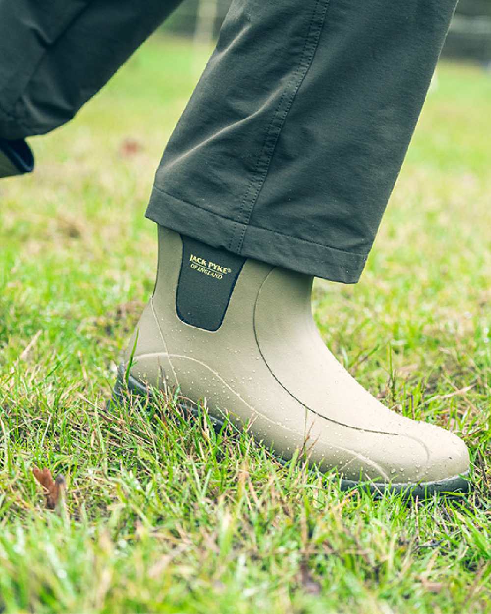 Green coloured Jack Pyke Ankle Wellington Boots on grass background