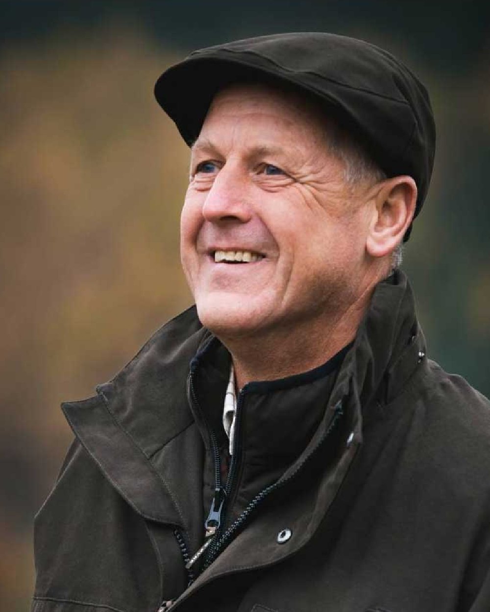 Olive coloured Jack Pyke Ashcombe Flat Cap on blurry background