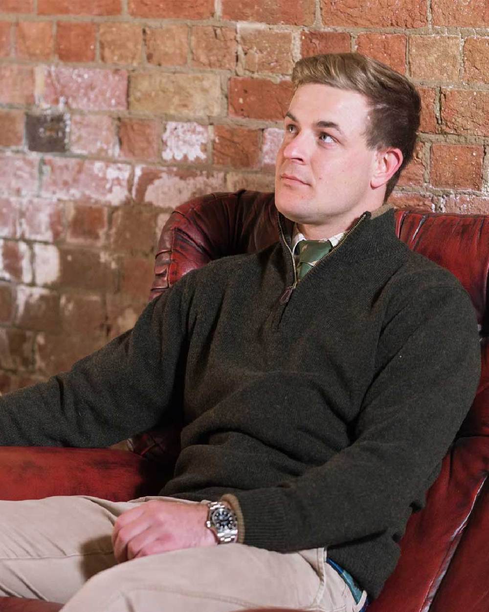 Dark Olive coloured Jack Pyke Ashcombe Lambswool Zip Knit Pullover on brick wall background