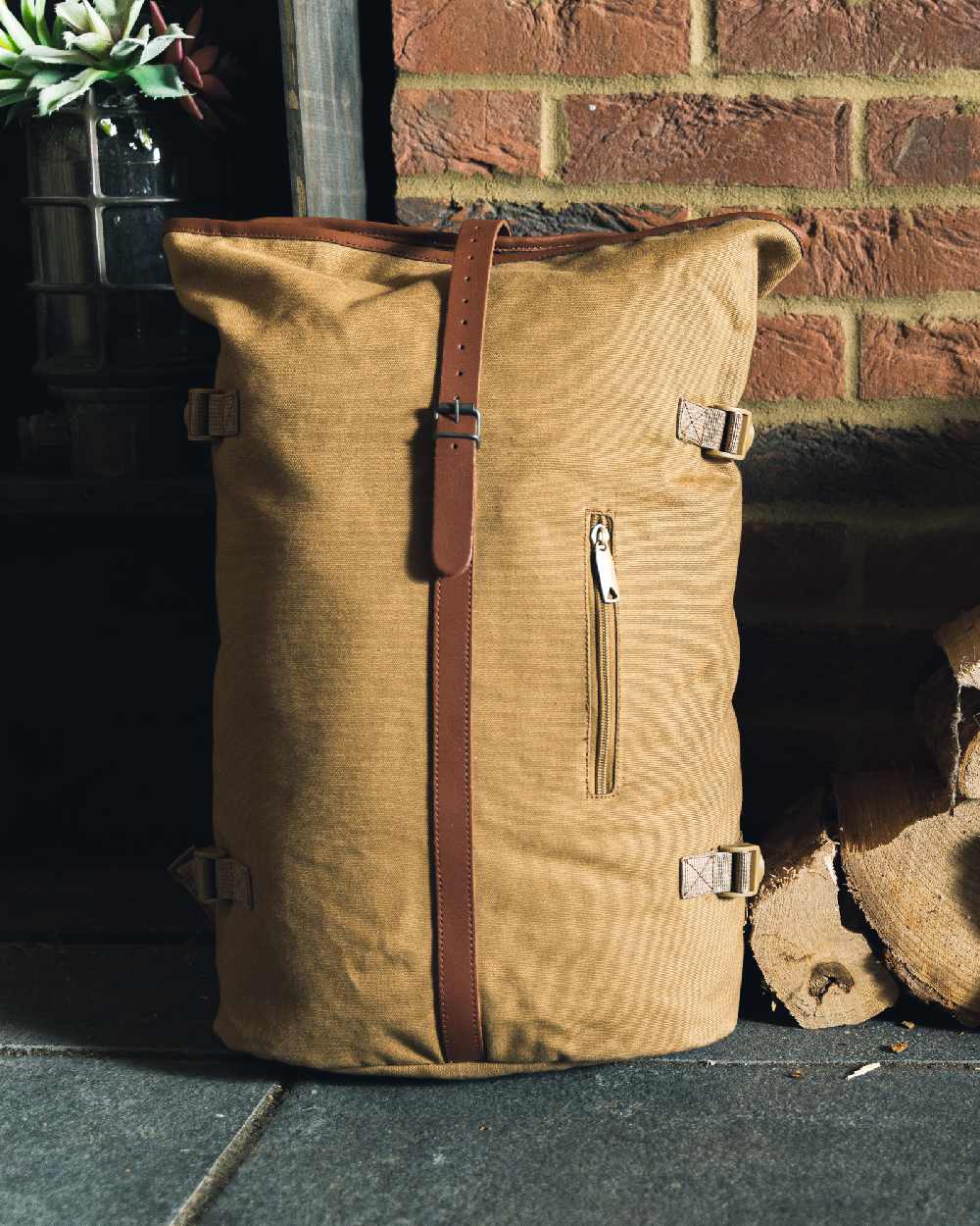 Fawn coloured Jack Pyke Canvas Fold Top Rucksack on brick wall background