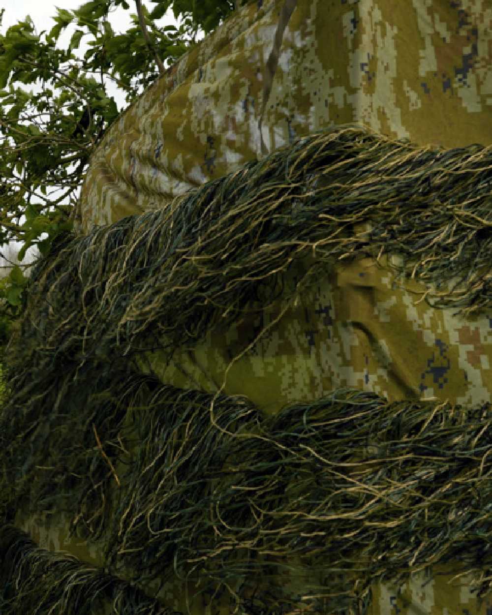 Camo coloured Jack Pyke Ghillie Hide Net on forest background