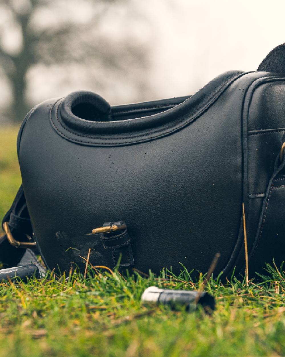 Brown coloured Jack Pyke Leather Cartridge Bag on grass background