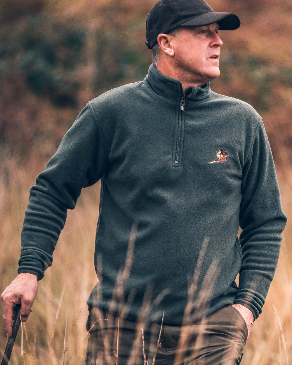 Green coloured Jack Pyke Pheasant Motif Fleece Pullover on blurry background