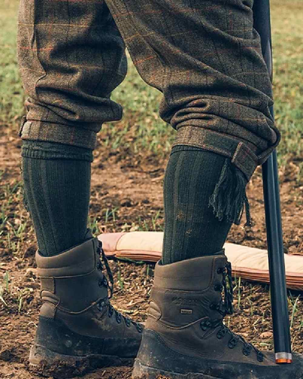 Green coloured Jack Pyke Plain Shooting Socks on mud background