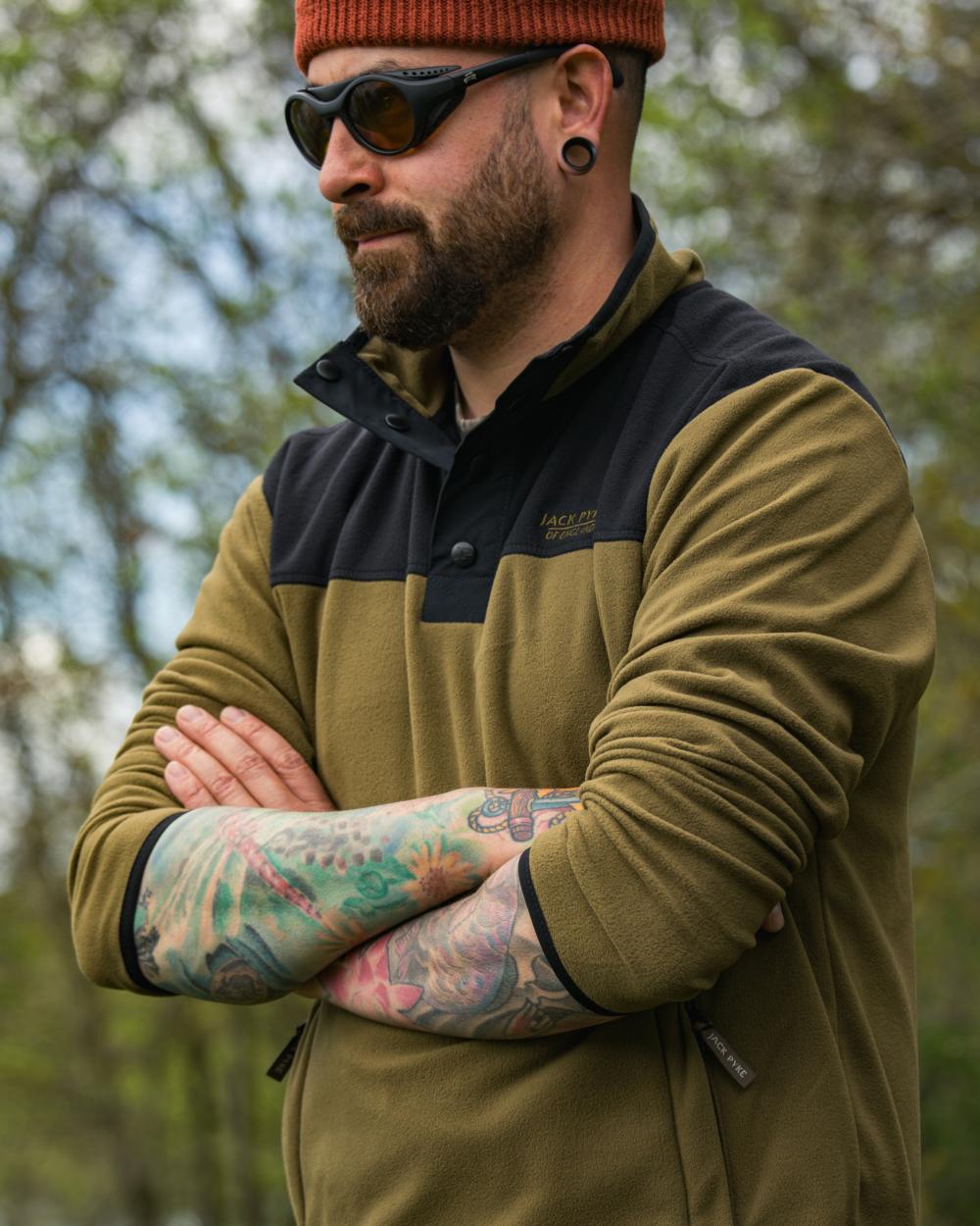 Dark Mustard coloured Jack Pyke Snap Neck Fleece Top on forest Background