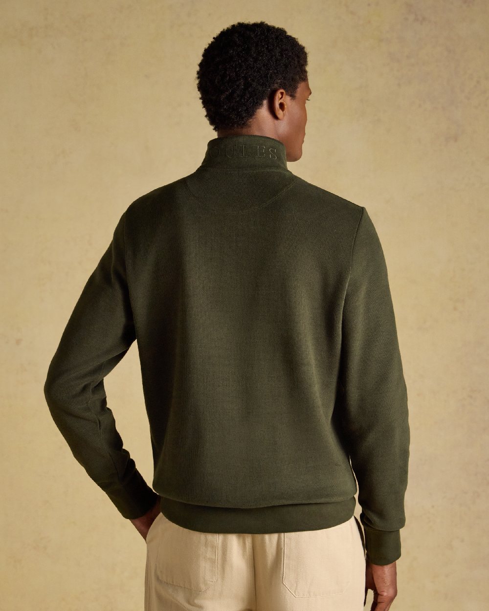 Green coloured Joules Alistair Quarter Zip Cotton Sweatshirt on beige background