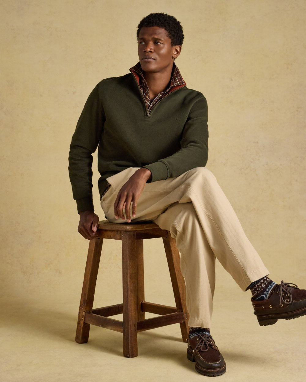 Green coloured Joules Alistair Quarter Zip Cotton Sweatshirt on beige background