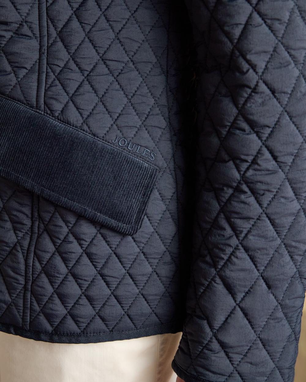 Navy coloured Joules Highclere Jacket on tan background