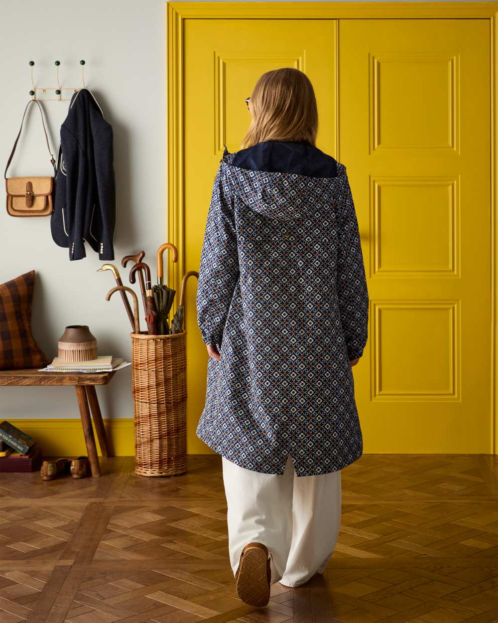 Flower Geo coloured Joules Holkham Waterproof Packable Raincoat With Hood on door background