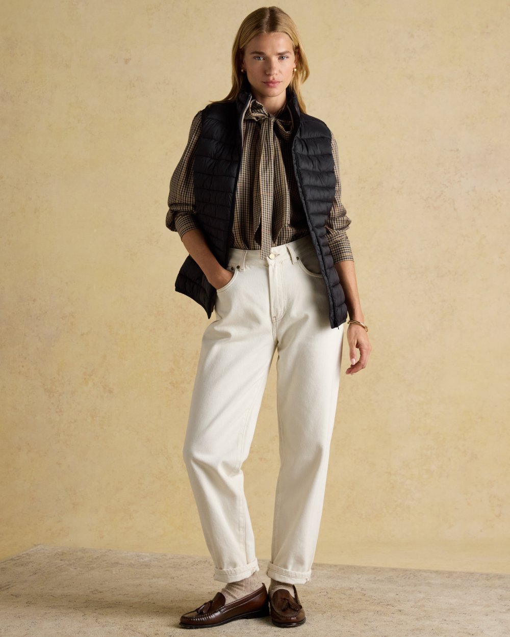 Black coloured Joules Kenley Showerproof Padded Gilet on beige background