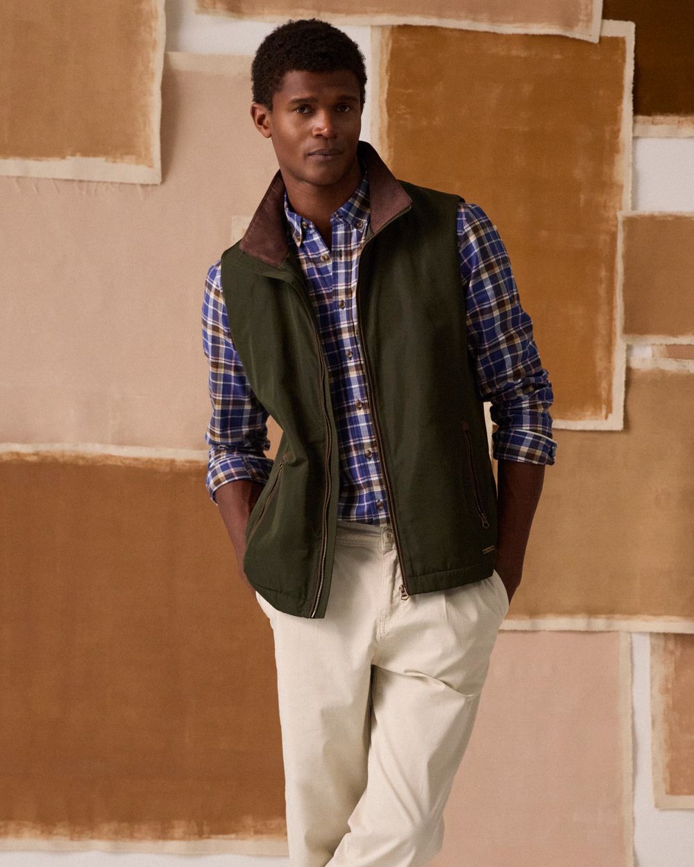 Green coloured Joules Mens Farnham Padded Fleece Lined Gilet on wall background