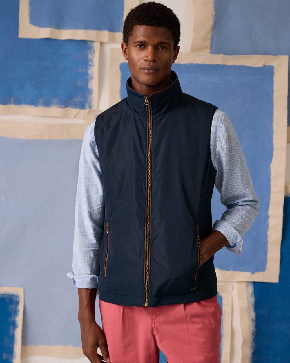 Navy coloured Joules Mens Farnham Padded Fleece Lined Gilet on wall background