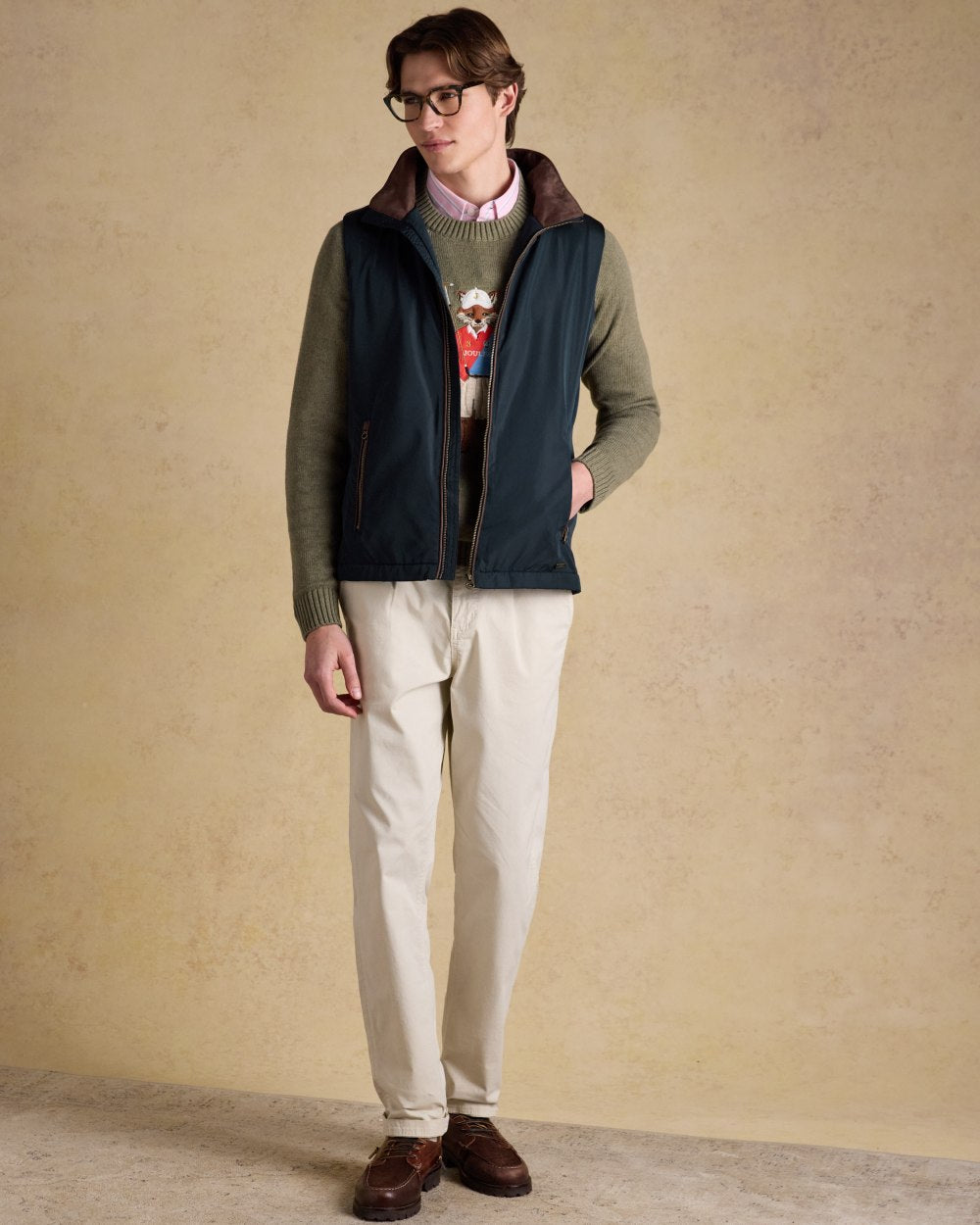 Navy coloured Joules Mens Farnham Padded Fleece Lined Gilet on wall background