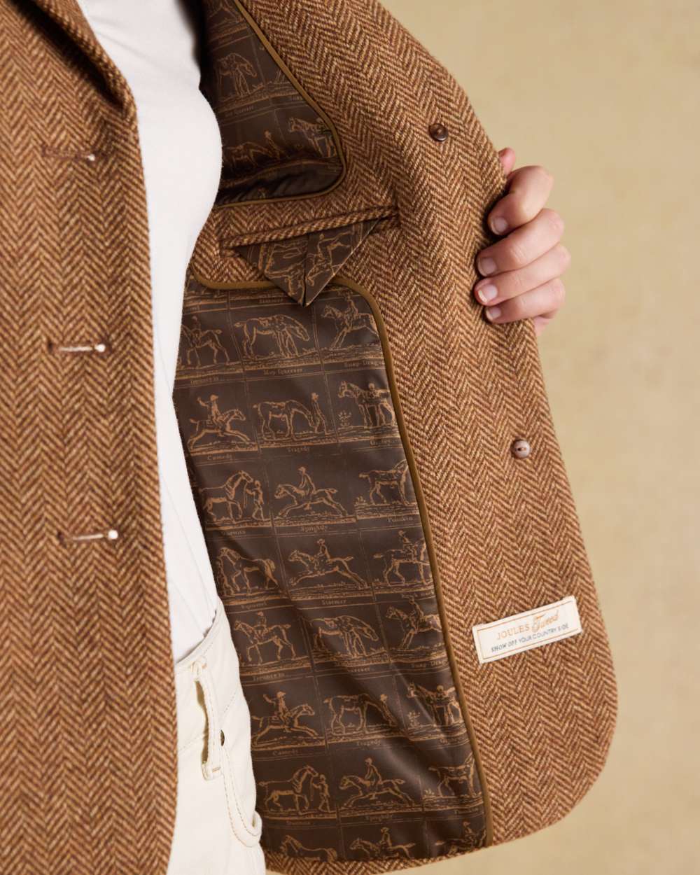 Brown Herringbone coloured Joules Womens Canterly Tweed Hacking Jacket on wall background