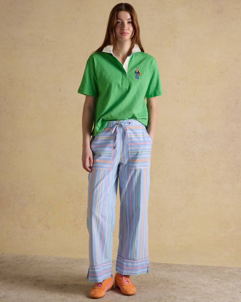 Green coloured Joules Womens Jonty Short Sleeve Cotton Rugby Shirt on wall background