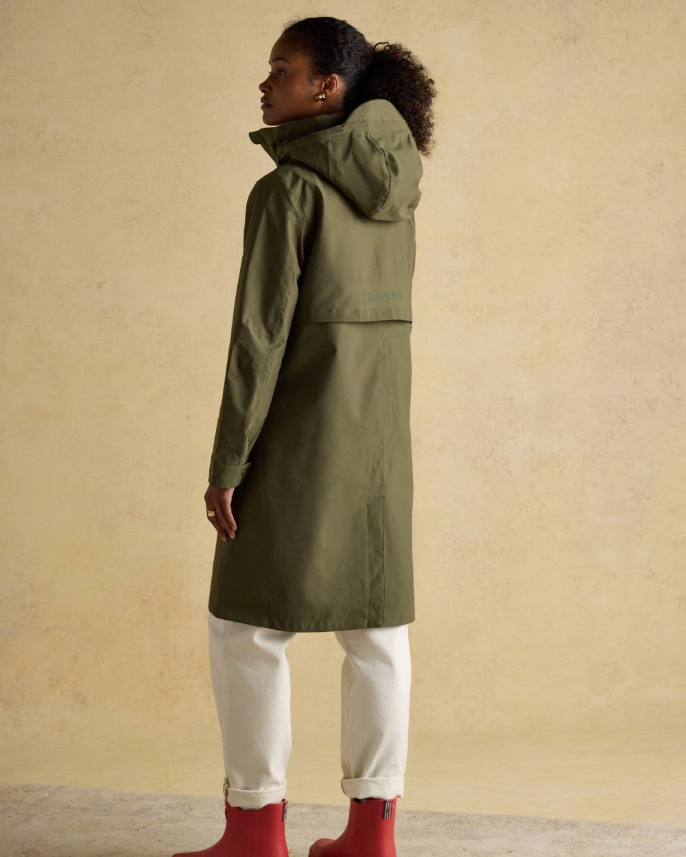 Green Grapeleaf Coloured Joules Womens Rainaway Waterproof Longline Raincoat on Indoor background