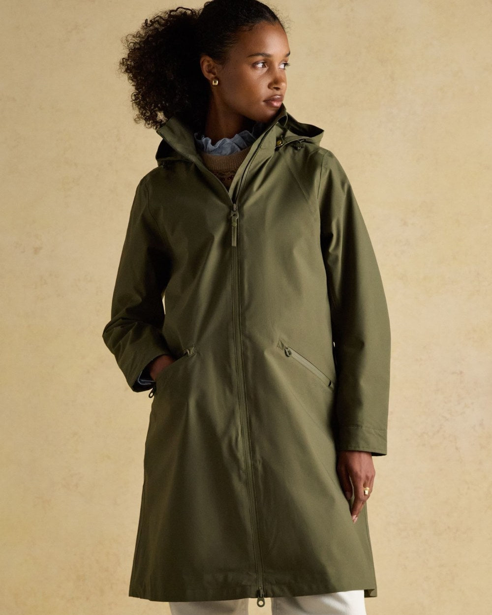 Green Grapeleaf Coloured Joules Womens Rainaway Waterproof Longline Raincoat on Indoor background