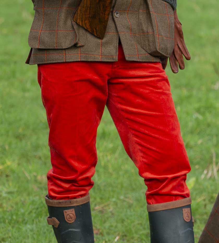 Laksen red corduroy trousers with green shooting wellingtons with grass background.