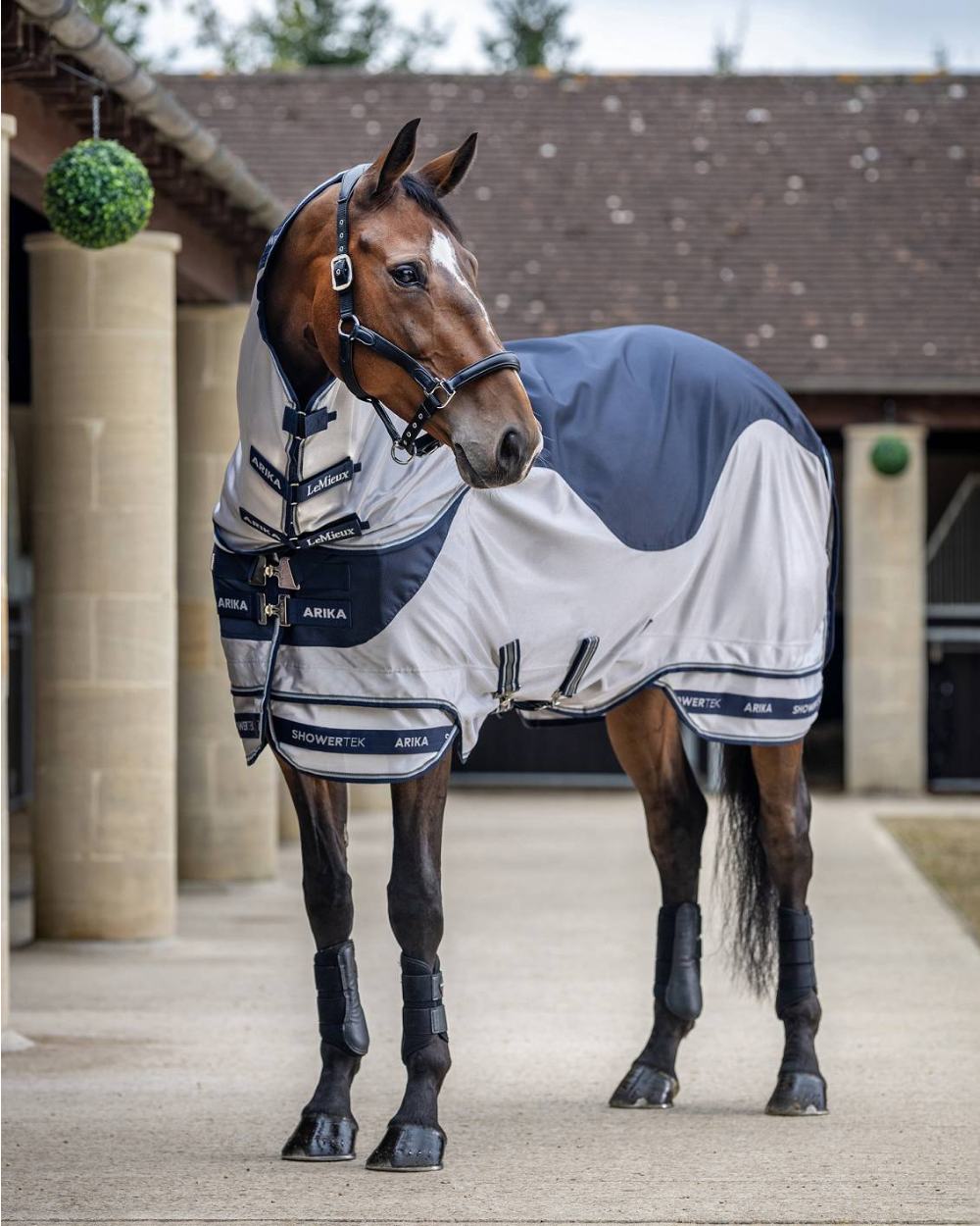 Navy coloured LeMieux Arika Shower Tek Fly Rug on blurry background