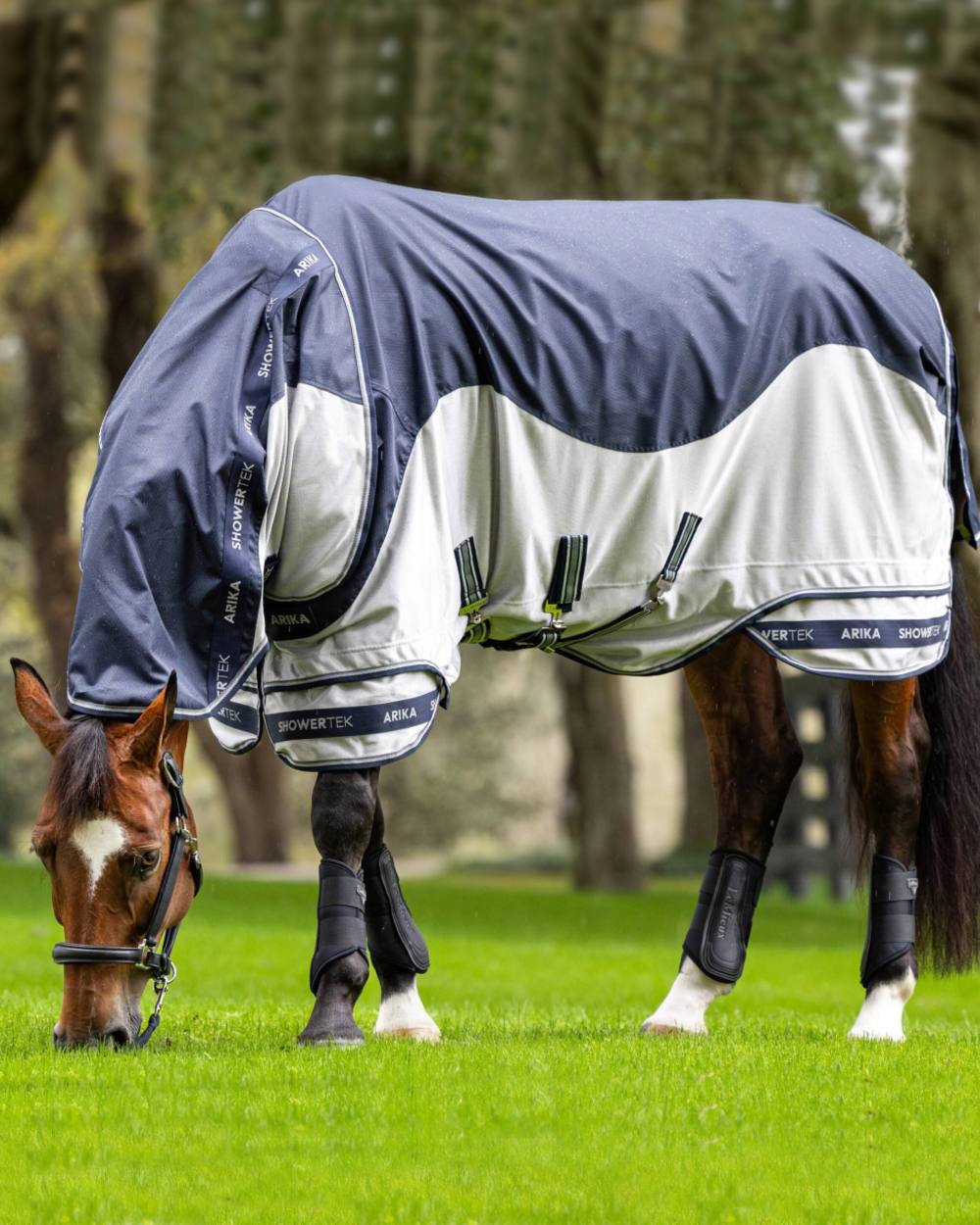 Navy coloured LeMieux Arika Shower Tek Fly Rug on blurry background