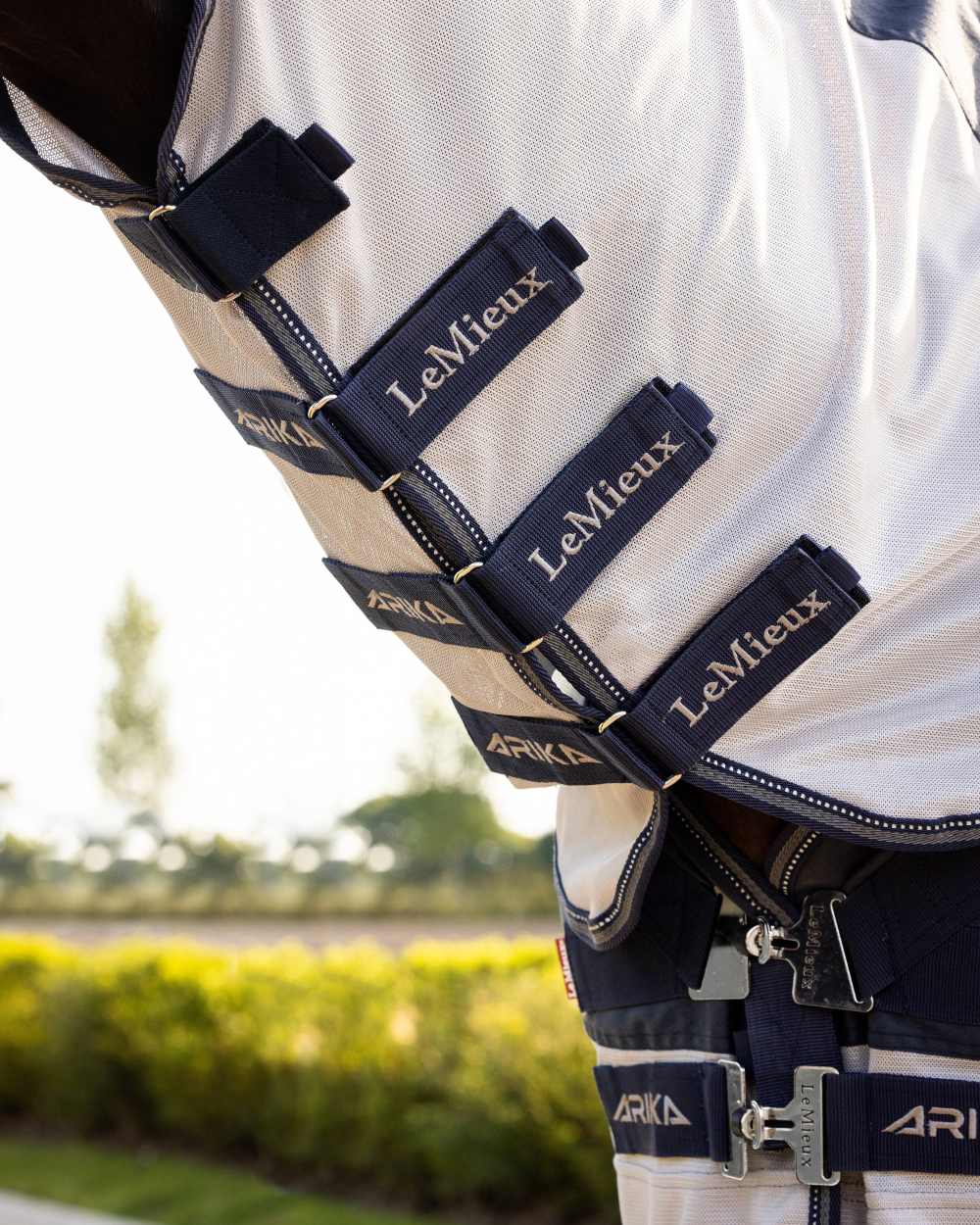 Navy coloured LeMieux Arika Shower Tek Fly Rug on blurry background