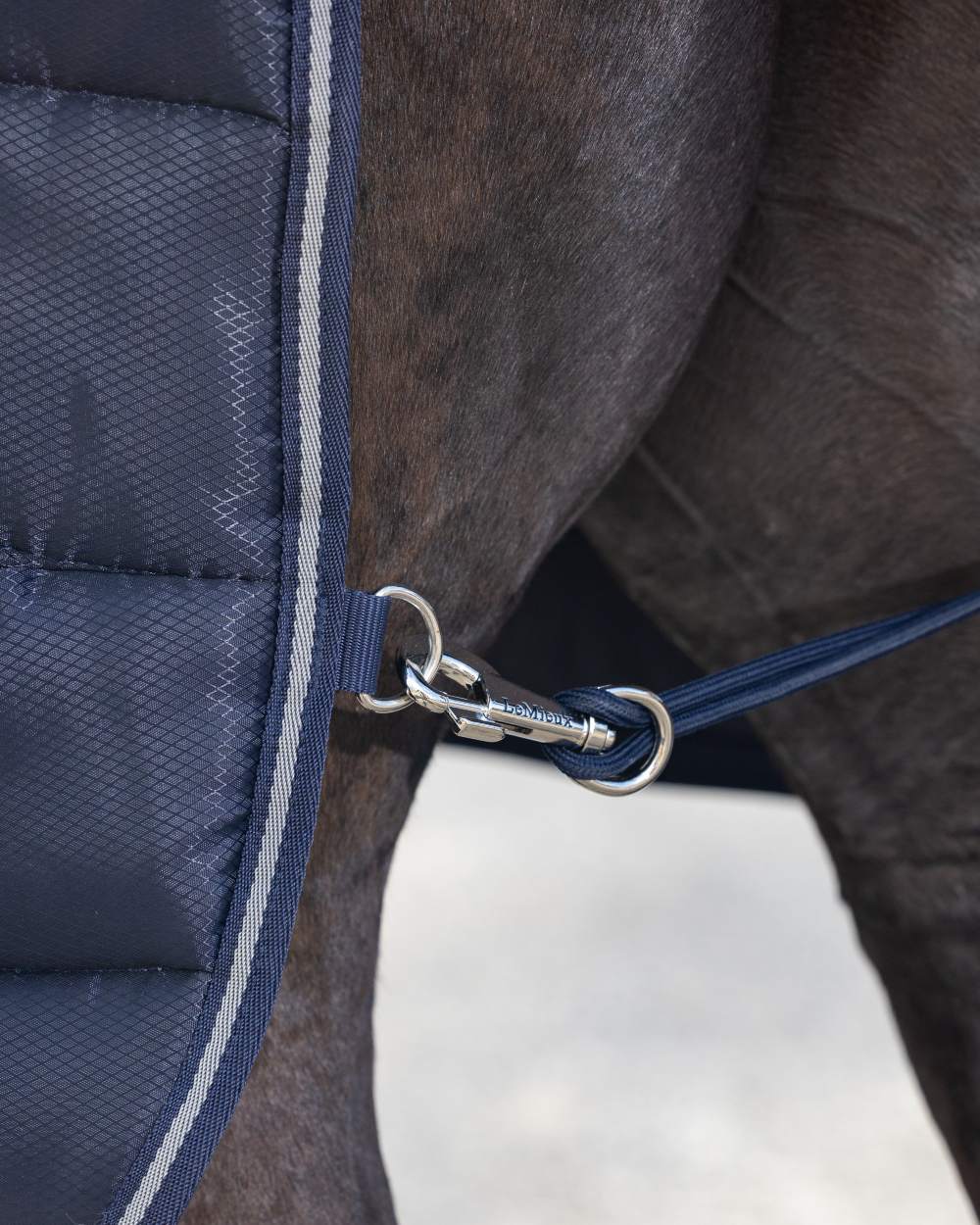 Navy coloured LeMieux Arika Stable-Tek 100g on outdoor background