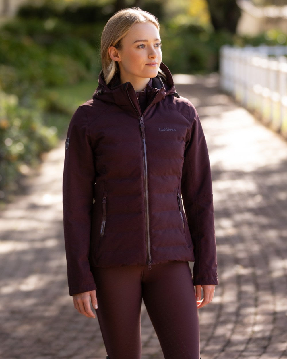 Damson coloured LeMieux Brooke Waterproof Hybrid Jacket on park background