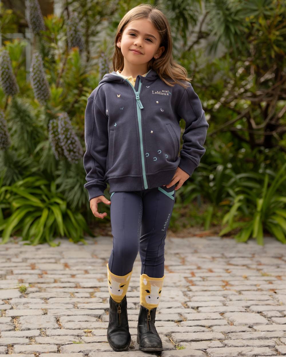 Dusk Blue coloured LeMieux Childrens Mini Charlie Zip Through Hoodie on backyard background
