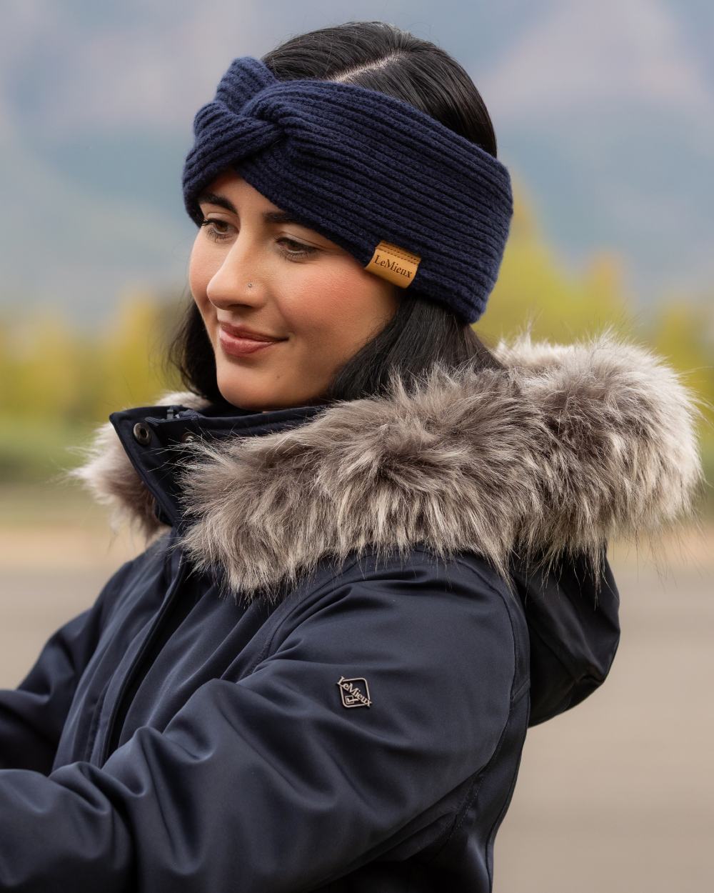 Navy coloured LeMieux Clara Rib Knot Headband on mountain background