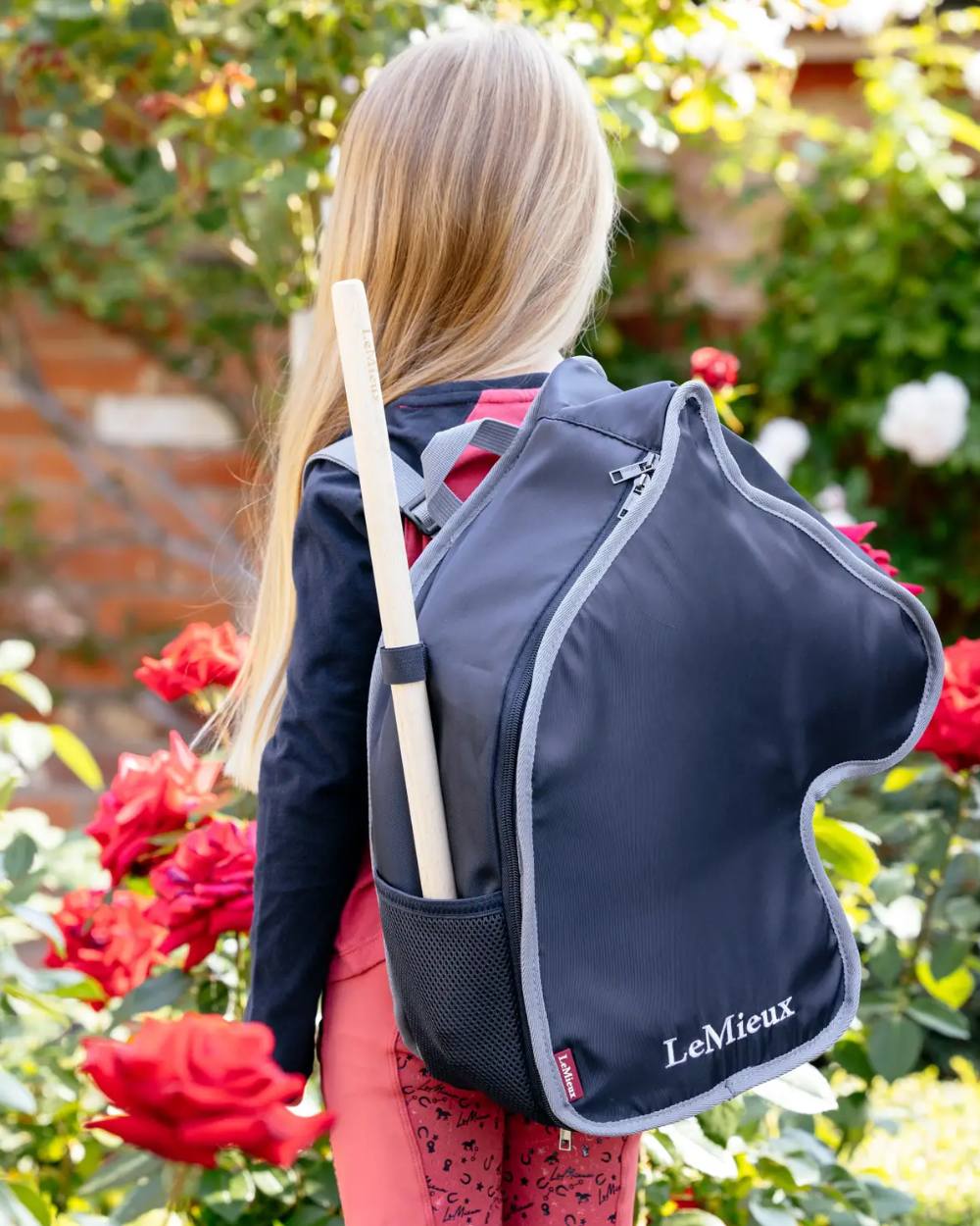 Navy coloured LeMieux Hobby Horse Carry Bag on garden background