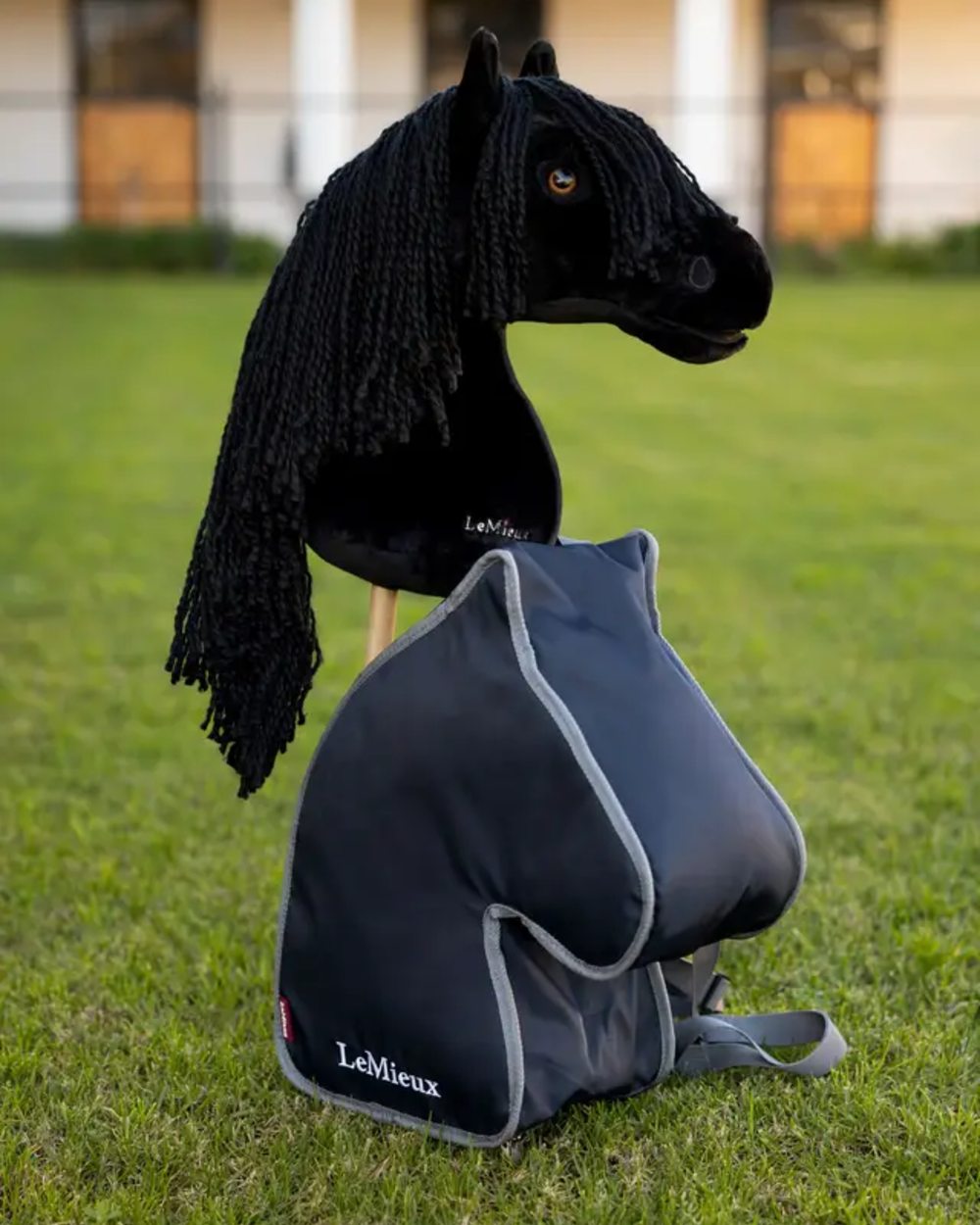 Navy coloured LeMieux Hobby Horse Carry Bag on garden background