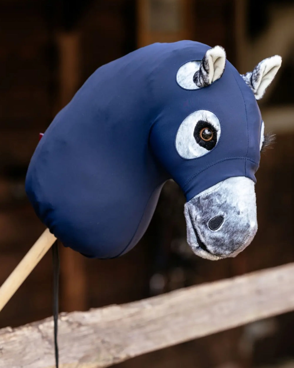 Navy coloured LeMieux Hobby Horse Clean Hood on blurry background