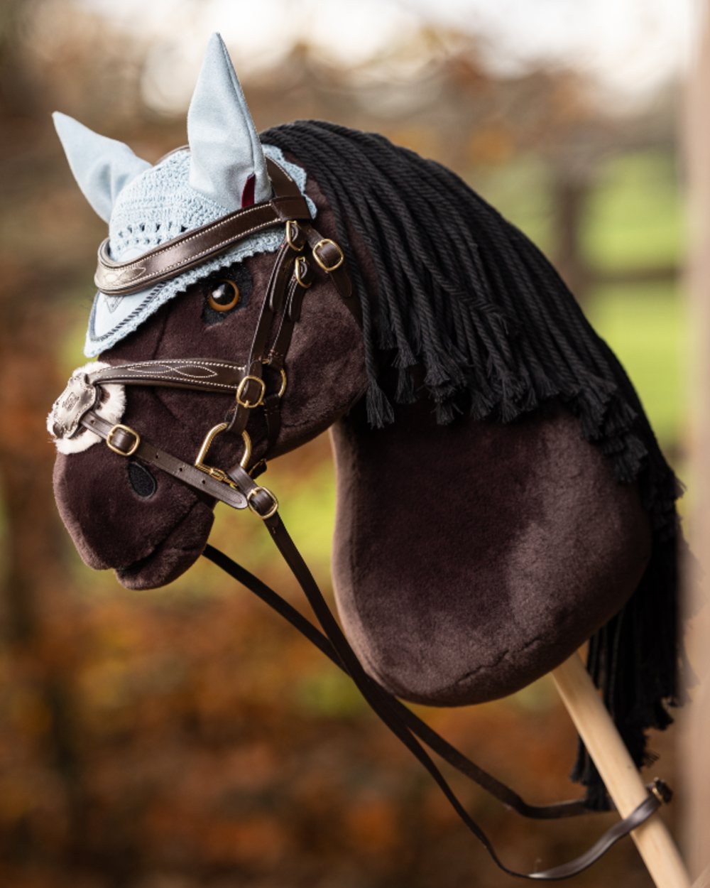 Brown coloured LeMieux Hobby Horse Grackle Bridle on blurry background