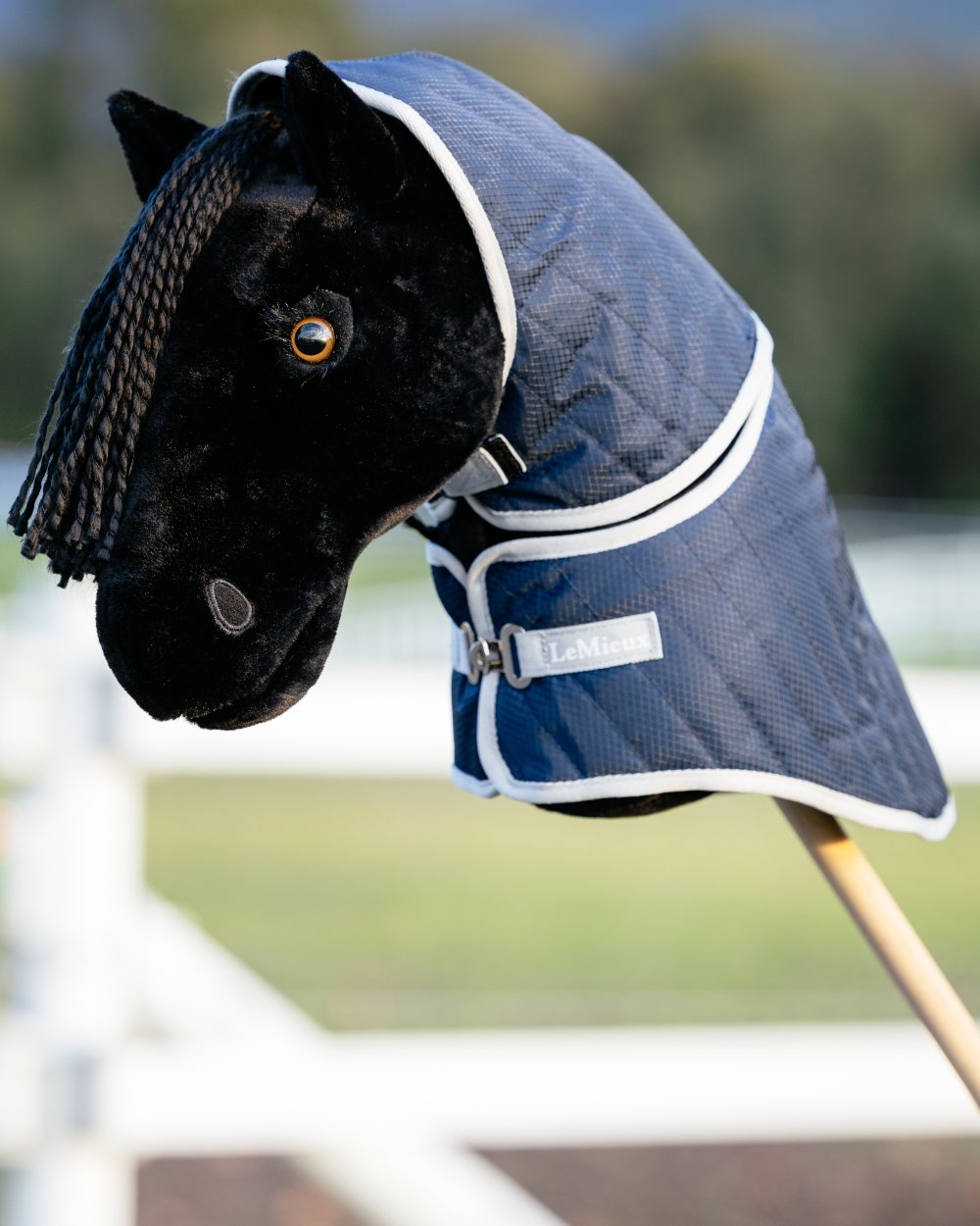 Navy coloured LeMieux Hobby Horse Stable Rug on blurry background