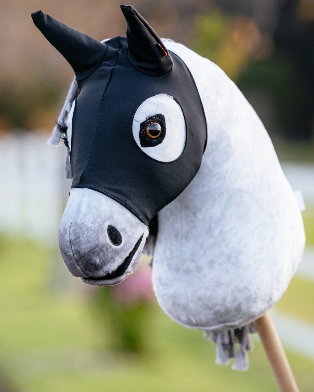 Black coloured LeMieux Hobby Horse Stay Calm Mask on blurry background