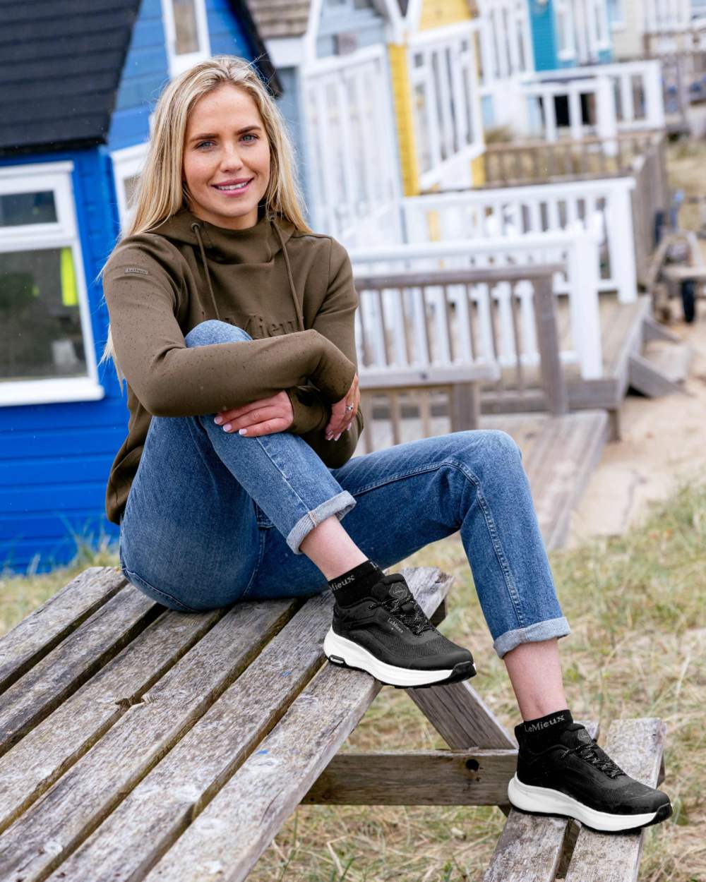 Model wearing black coloured LeMieux Womens Kanta Waterproof Trainers on beach background
