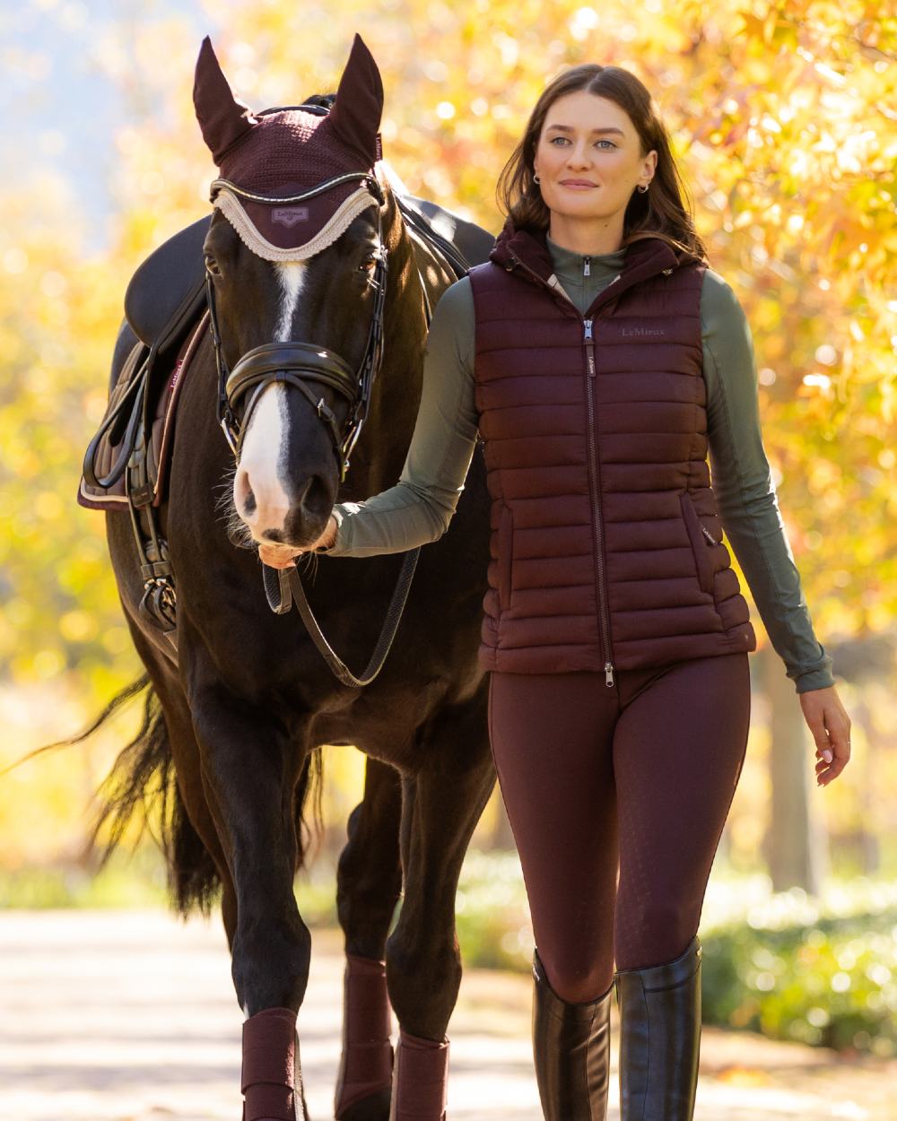 Damson coloured LeMieux Loire Fly Hood on leafy background